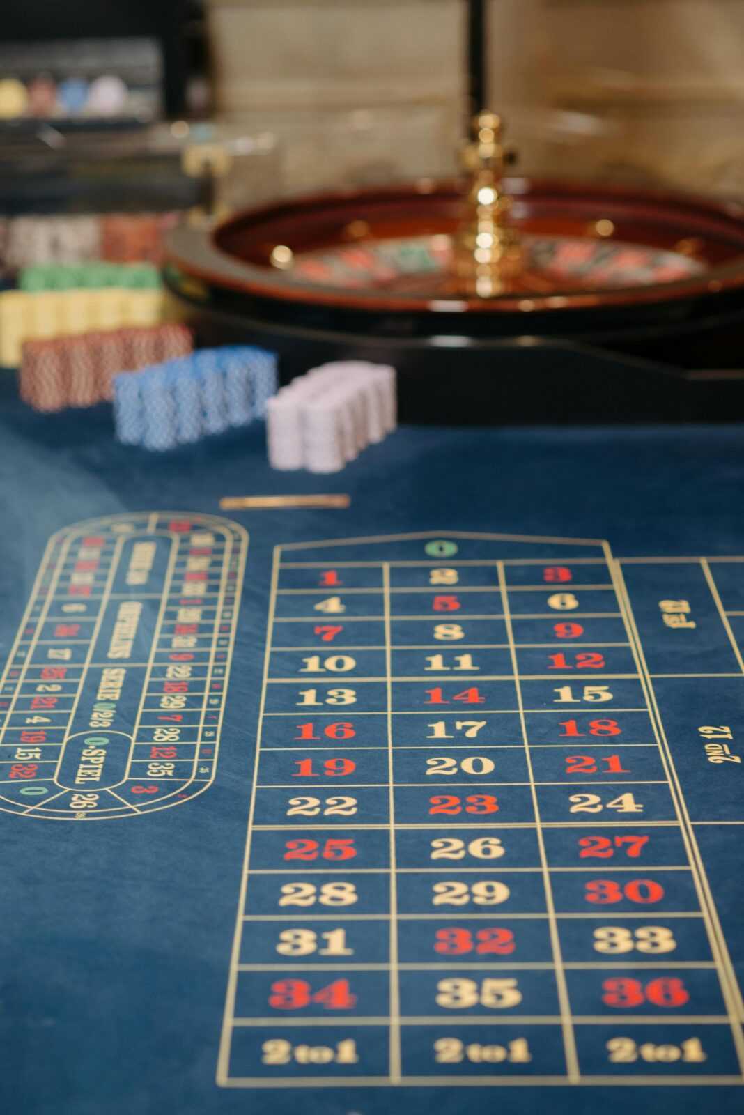 Close-up view of a roulette table with colorful chips and numbered layout in a casino setting.
